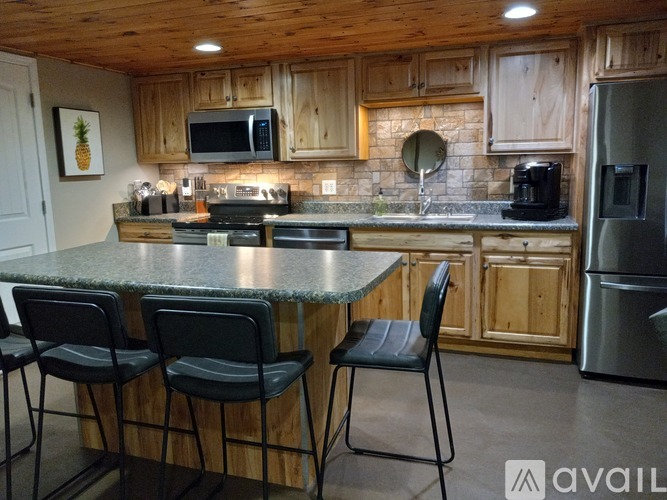 A kitchen with a granite countertop and wooden cabinets.