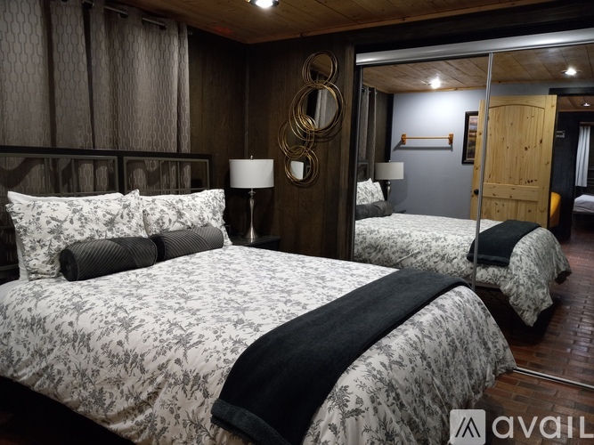 A bedroom with two beds and a mirror on the wall.