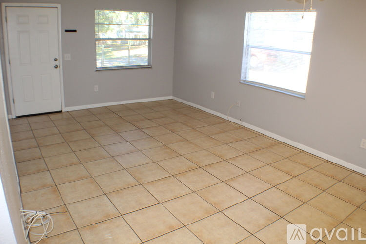 A room with a tiled floor and a window with a view of a street.