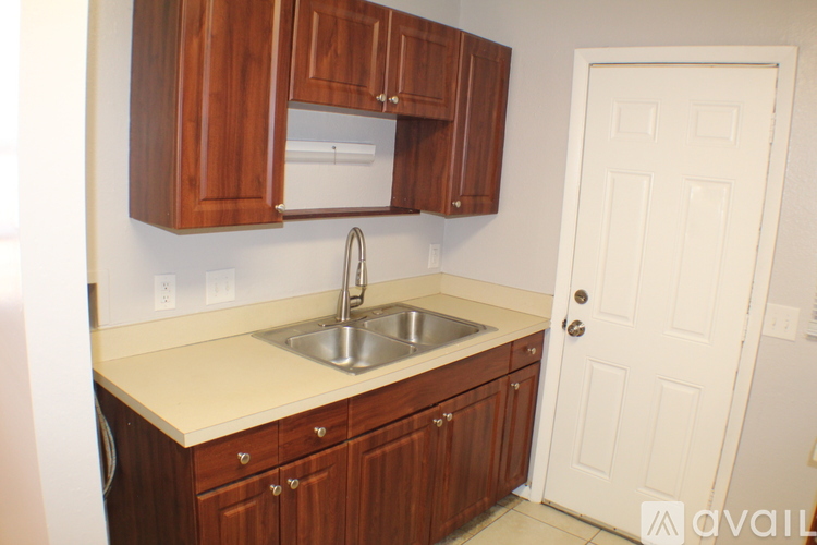 A kitchen with wooden cabinets and a white door.