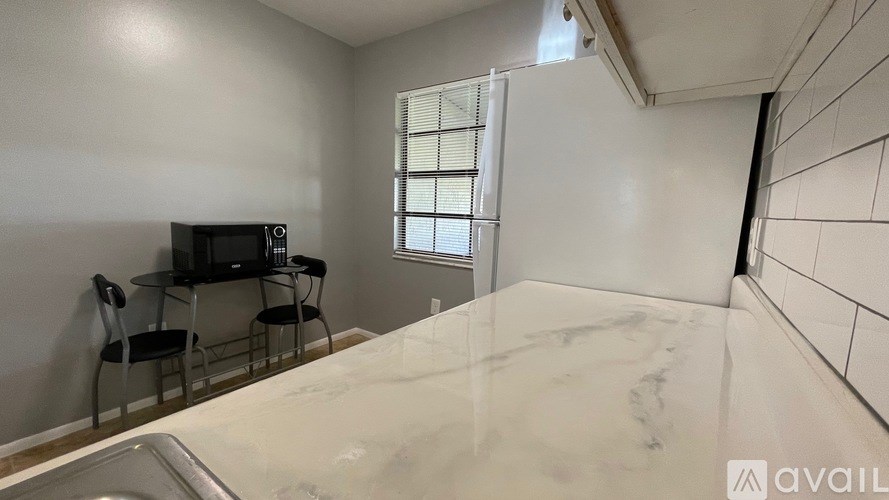 A kitchen with a marble countertop and a microwave on the counter.