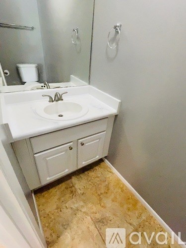 A bathroom with a sink, mirror, and toilet.