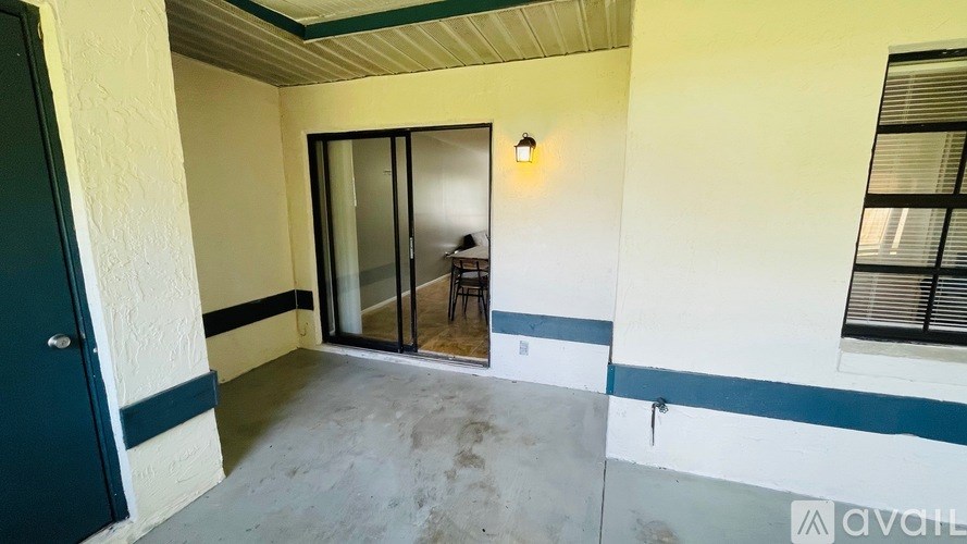 A room with a sliding glass door and a window with blinds.