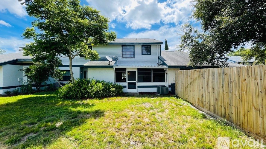 A white house with a wooden fence in front of it.
