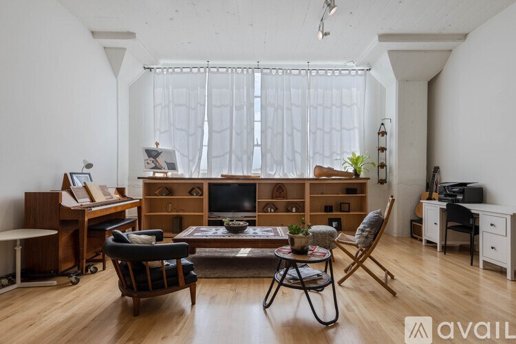 A living room with a wooden floor and furniture.