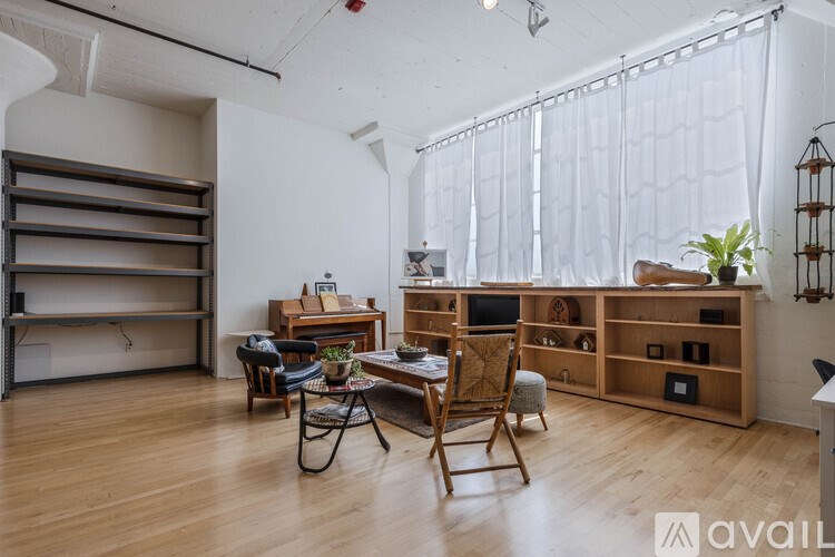 A room with wooden floors and furniture including a chair and a table.