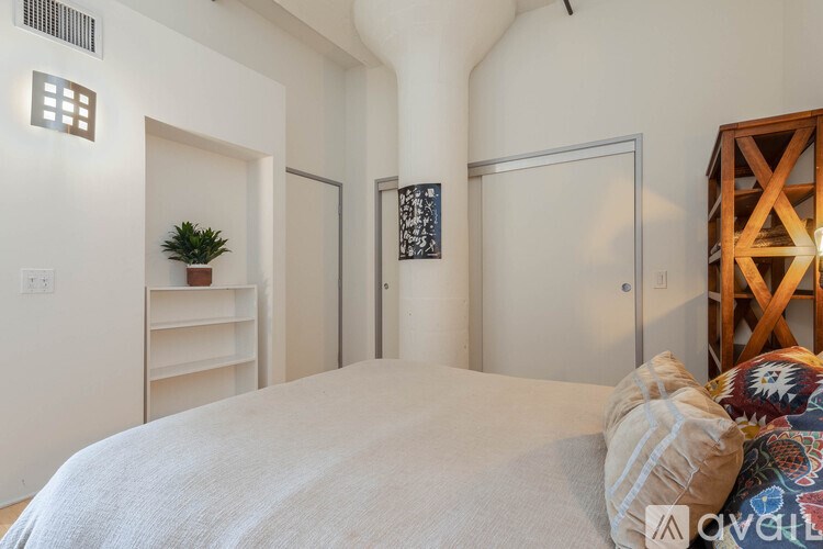 A bedroom with a large bed and a wooden structure to the right.