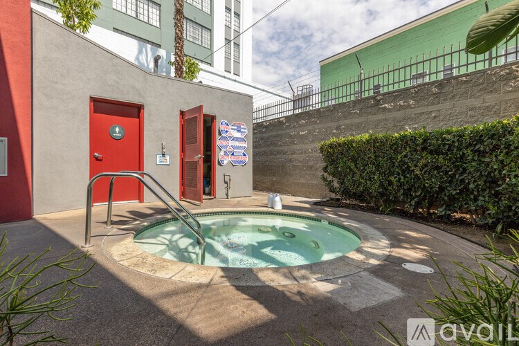 A red door is on the left side of a wall with a pool in the middle.