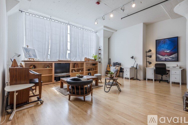 A living room with a white couch, a wooden coffee table, and a television.