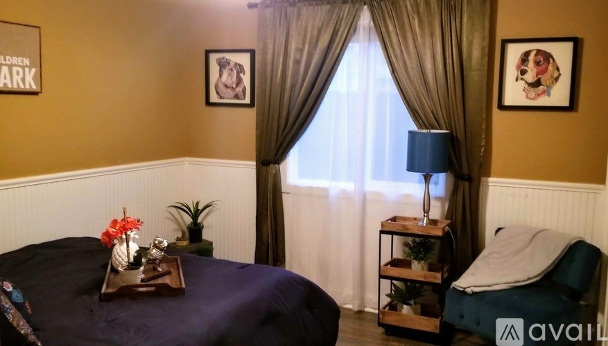 A room with a bed, a nightstand, and a window with curtains.