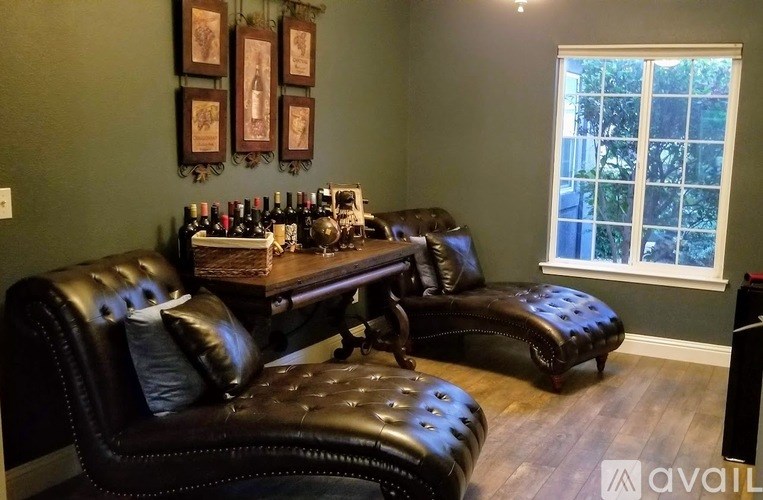 A black leather sofa with a wooden table in front of it.