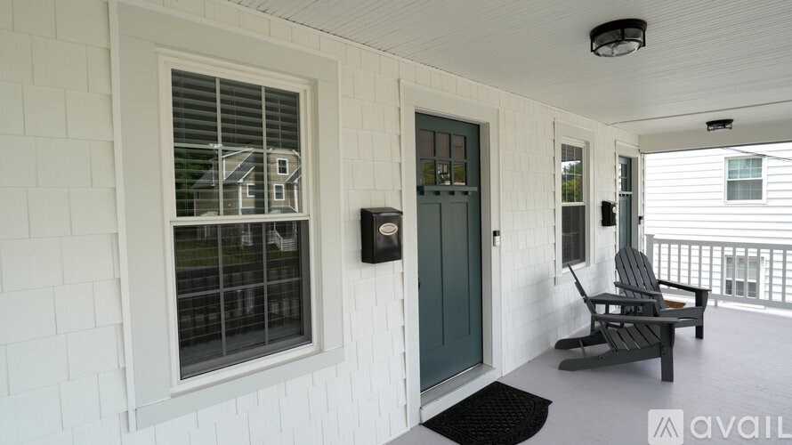 A balcony with a chair and a doorbell.