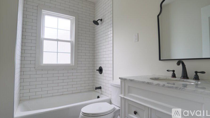 A white bathroom with a tub, toilet and sink.