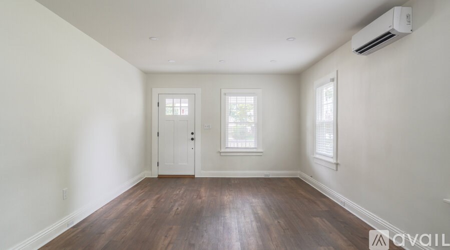 A room with wooden floors and two windows.