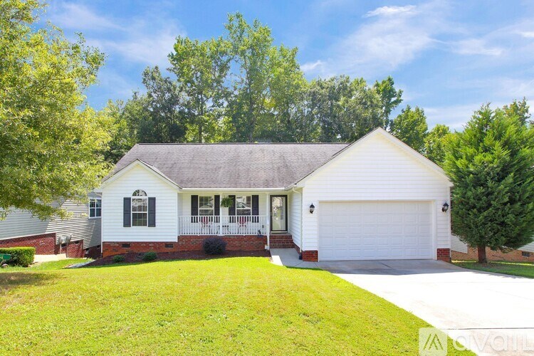 A white house with a grey roof and a garage door.