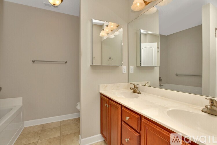 A bathroom with a white sink and wooden cabinets.