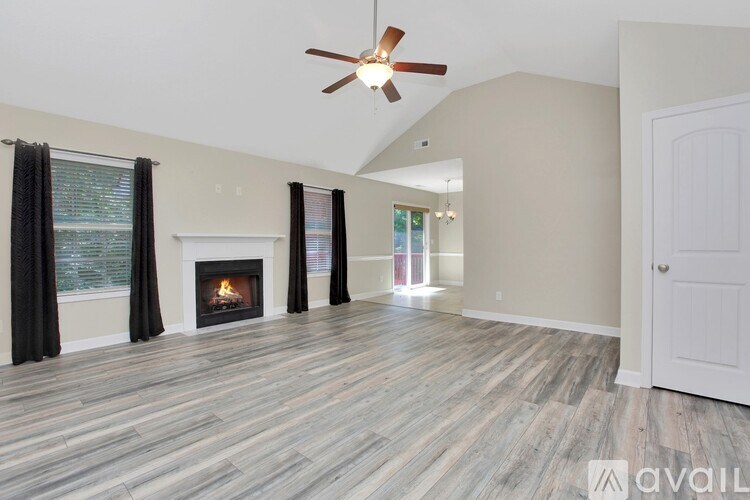 A living room with a fireplace and a ceiling fan.