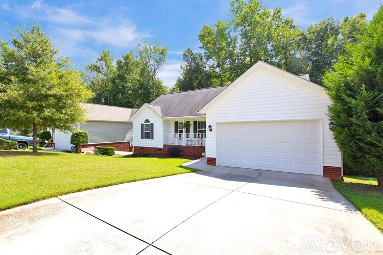 A white house with a grey roof and a white garage door.
