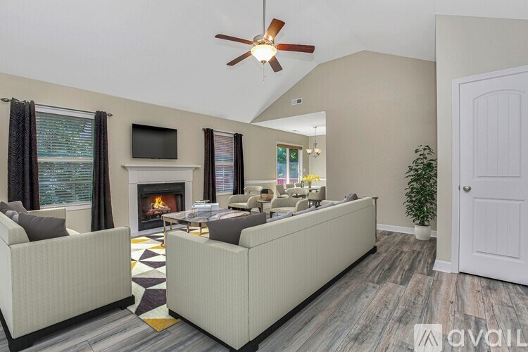 A living room with a fireplace and a television on the wall.