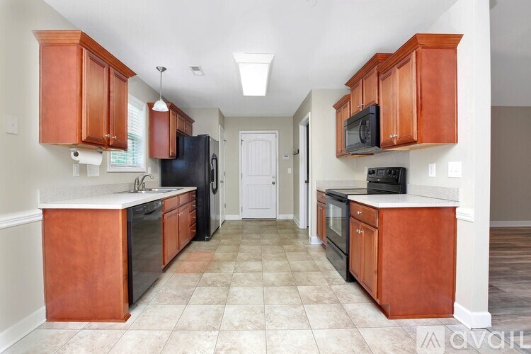A kitchen with brown cabinets and black appliances.
