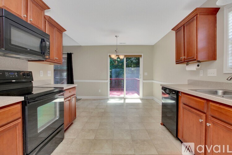 A kitchen with wooden cabinets and black appliances.