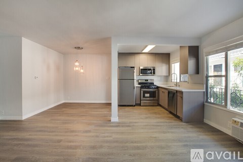 A kitchen with a refrigerator, microwave, and oven is available for rent.