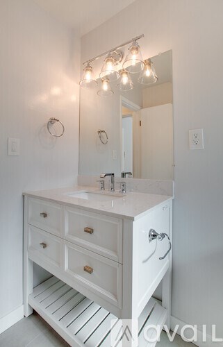 A white bathroom vanity with a mirror and lights above it.