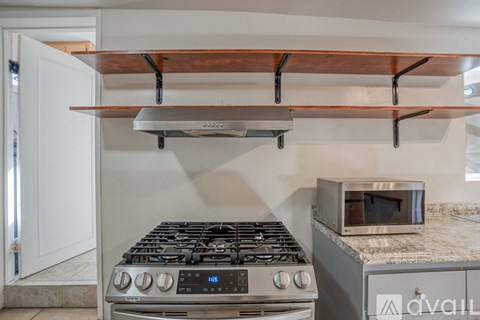 A modern kitchen with a stove and a microwave oven.