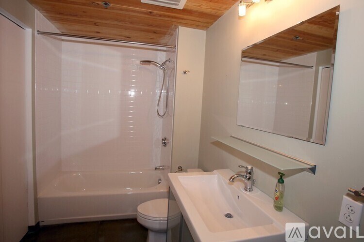 A bathroom with a white sink, toilet, and shower.