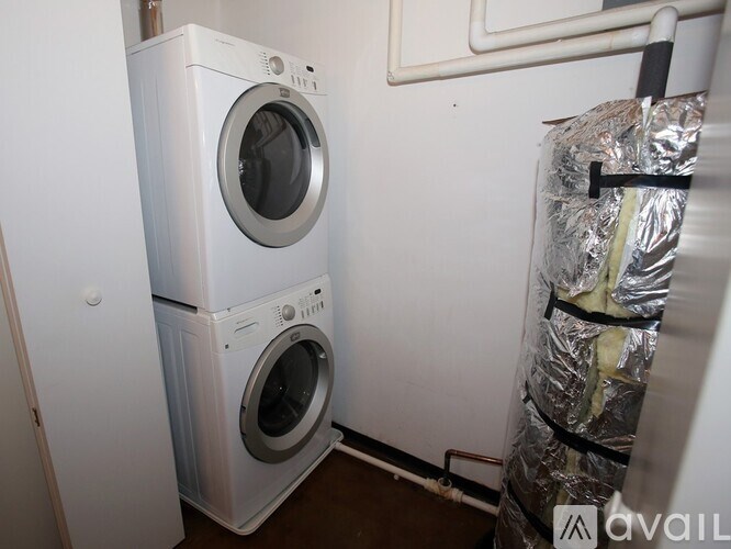 A stack of two white front loading washing machines in a laundry room.