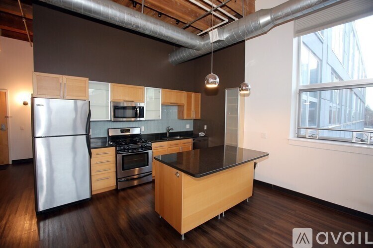 A kitchen with a refrigerator, stove, and microwave.