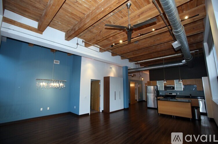 A spacious room with wooden floors and a ceiling fan.