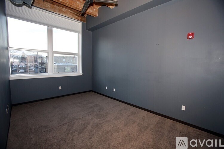 A room with a large window and a fire extinguisher on the wall.