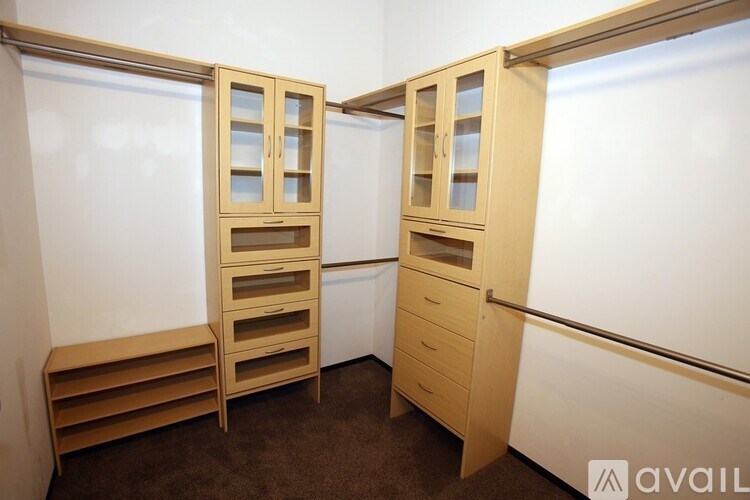 A room with two wooden cupboards and drawers.