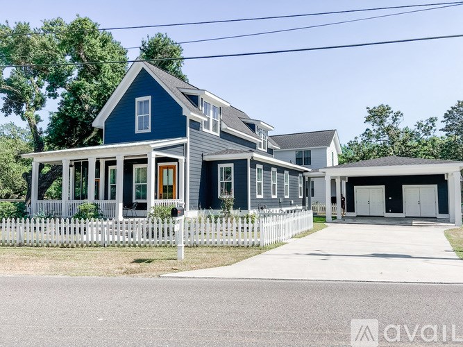 A blue house with a white picket fence in front.