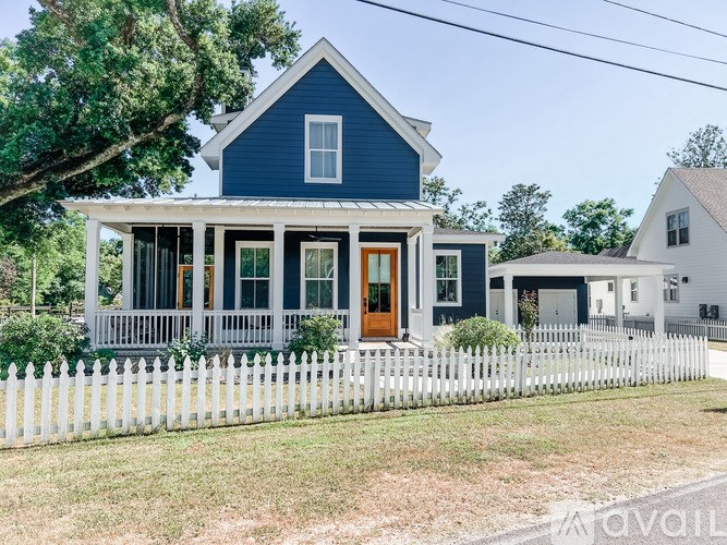 A blue house with a white picket fence in front.