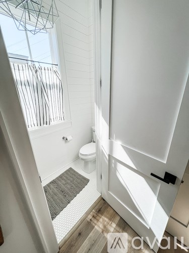 A bathroom with a toilet and a window.