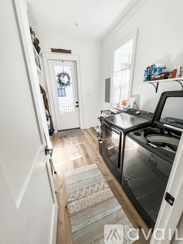 A kitchen with a black stove top oven and a white door.