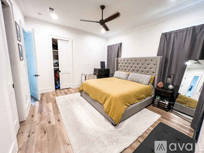 A bedroom with a bed, dresser, and mirror.