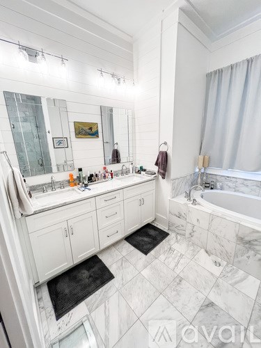 A bathroom with marble tiles and a large mirror.