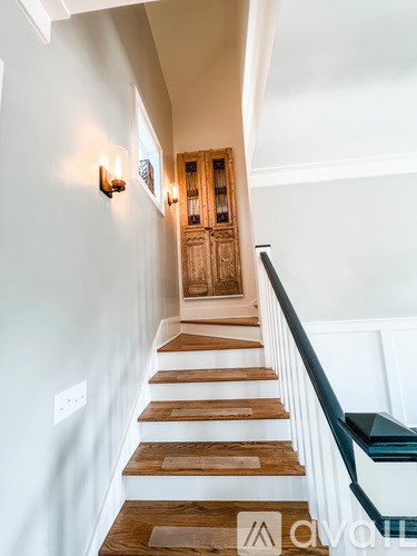 A staircase with wooden steps and a black railing.