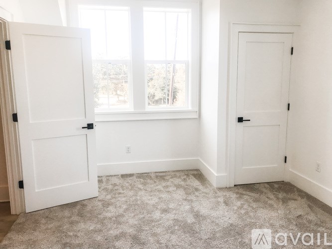 A room with two white doors and a carpeted floor.