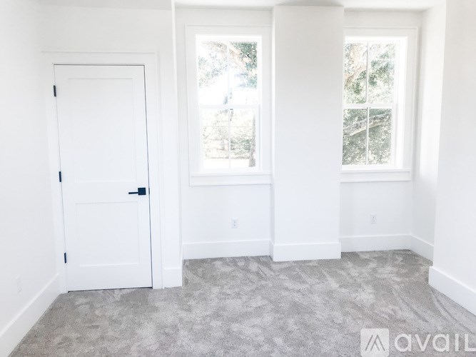 A room with a door and two windows.