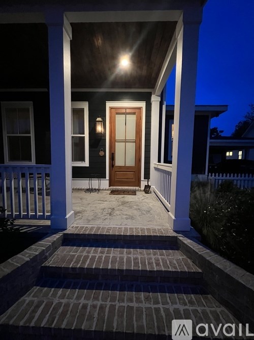A house entrance with a wooden door and steps leading up to it.