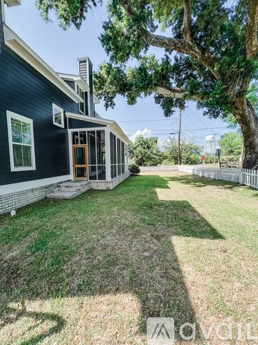 A house with a blue exterior and a tree in the front yard.