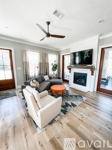 A living room with a fireplace and a television on the wall.