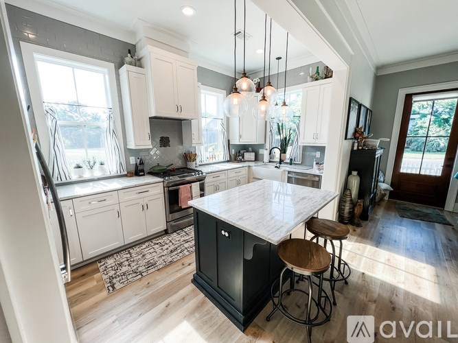 A kitchen with a large island and stools.