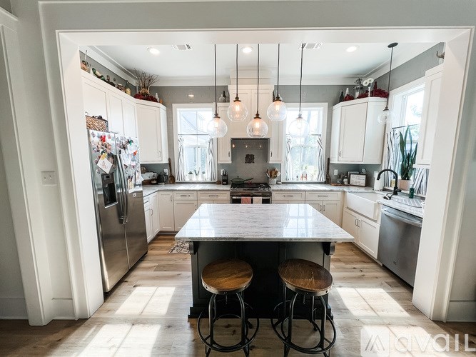 A modern kitchen with a large island and bar stools.