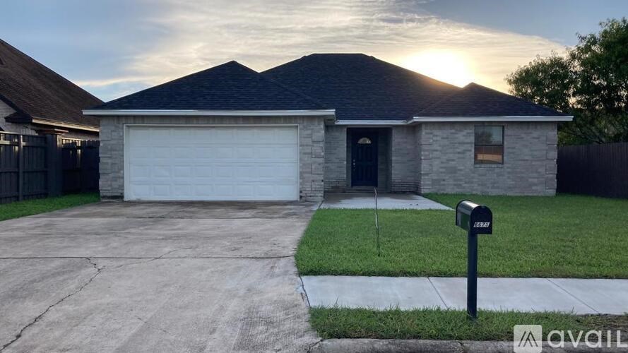 A house with a garage and a mailbox in front.