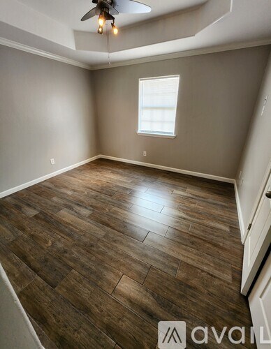 A room with wooden flooring and a ceiling fan.